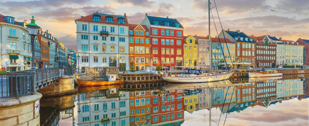 Tourist boat crossing one of the canals of Copenhagen at sunset.