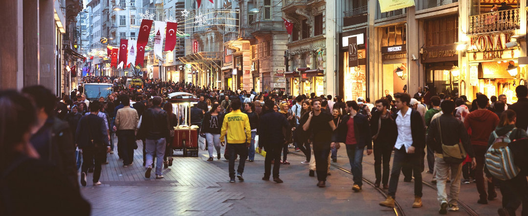Istanbul's Istiklal Street with crowds of people, the tramway lines can be seen.