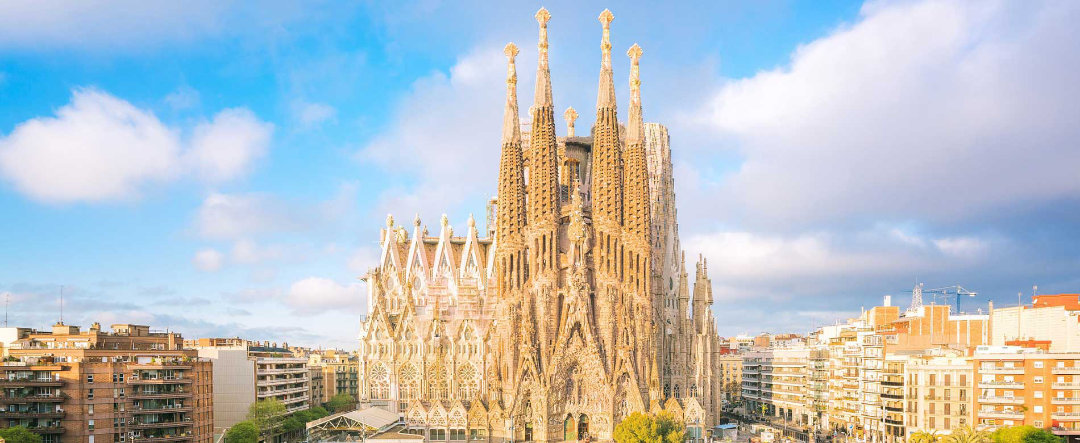 Paisaje de la ciudad de Barcelona desde lo alto, con vista de la Sagrada Familia y parque.